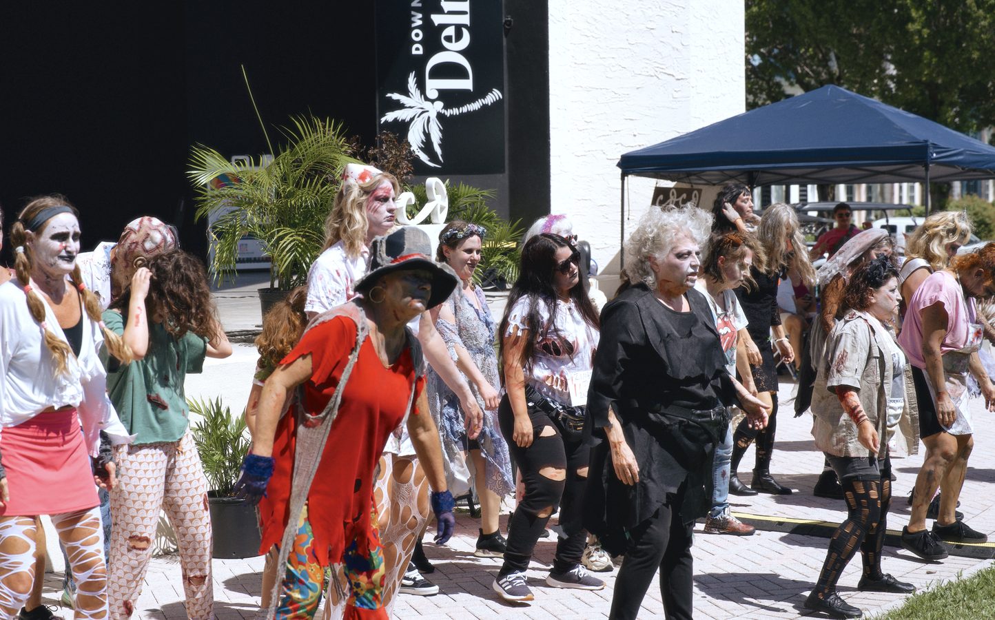 A line of costumed dancers in zombie make-up mid-routine outside the Old School Square pavilion.