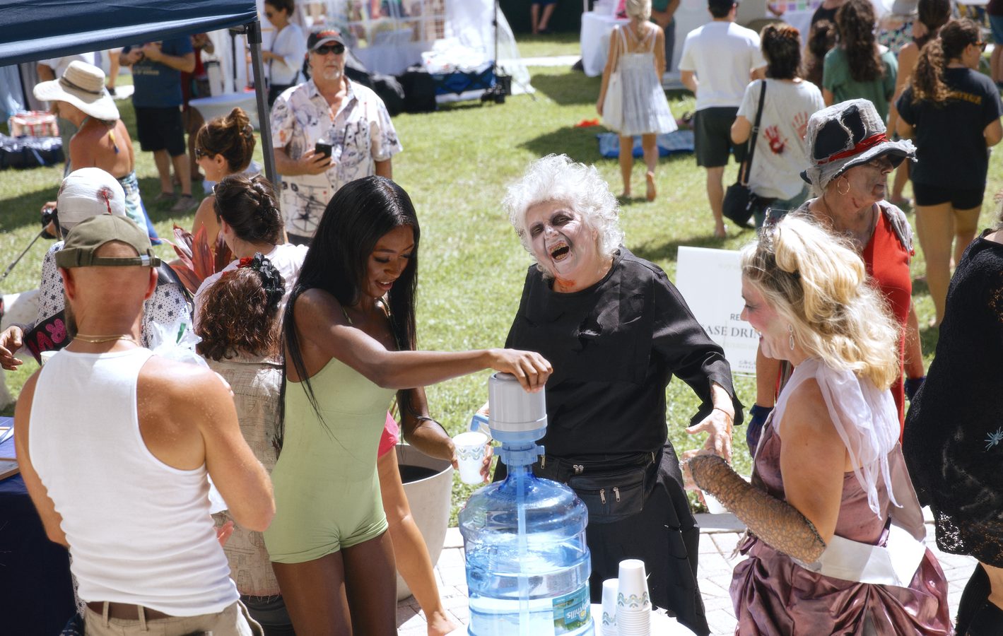 A guest in zombie make-up laughing with friends at the free water station.